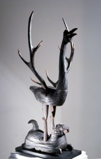 Sculpture of a phoenix with spread wings in the form of deer antlers, resting on a reclining tiger