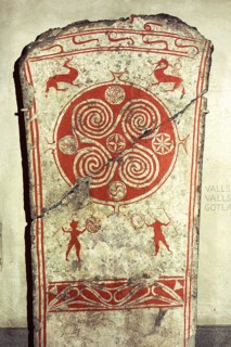 Memorial picture stone decorated with whorls symbolising the sunand vignettes from the hunt