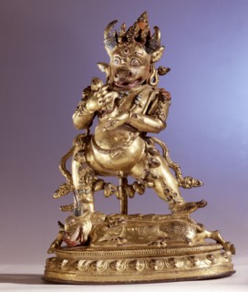 Ekavira Bharavara, the bull headed deity tramples on a demon lying face down on the back of a prostrated bull having a dakini engraved on its rump