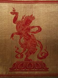 Sino Tibetan silk and gold brocade altar cloth depicting eight auspicious emblems interspersed by puja devis (offering goddesses) who offer gifts to the five Dhyani Buddhas, or Buddhas of meditation