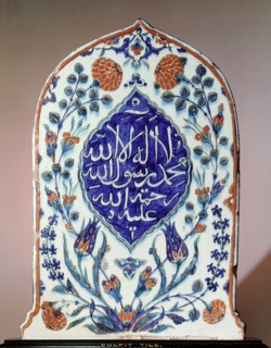 A tombstone shaped tile, possibly made for a mausoleum, bearing the creed there is no God but God; Muhammad is his prophet; may God show mercy to him