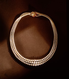 A three strand pearl necklace with gold clasp