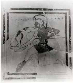 A terracotta slab painted with a running hoplite carrying a spear and shield