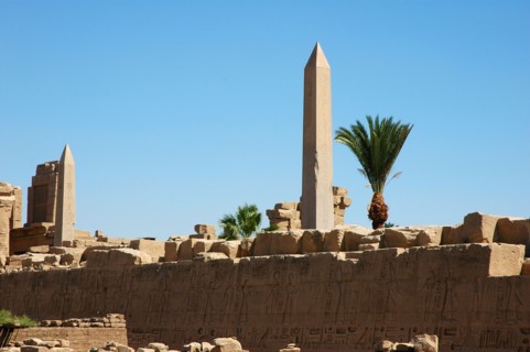 View of a hieroglyph wall and the two obelisks of Tuthmosis II (left) and Queen Hatshepsut (right) in the background