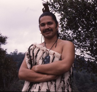A Maori man wearing traditional dress and a hei-tiki pendant