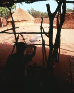 Weaving on the horizontal double heddle loom typical of West Africa