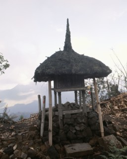 A tiny shrine, its' roof recalling the cosmic mountain, standing before the volcano Gunung Batur