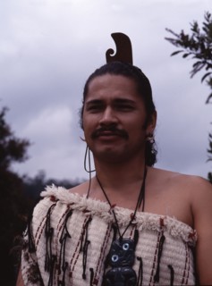 A Maori man wearing traditional dress and a hei-tiki pendant