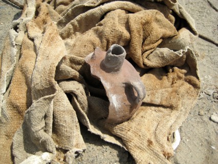 Pottery remains and plain textile from a disturbed burial