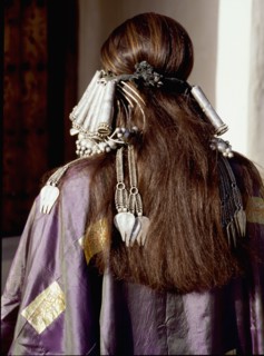 A woman wearing an elaborate silver headdress and traditional costume