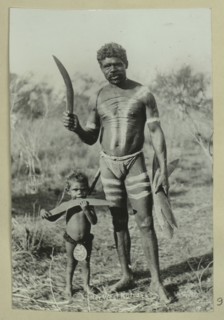 Aboriginal man and a child holding boomerangs