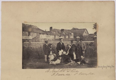 Group of men in civilian clothes in front of buildings