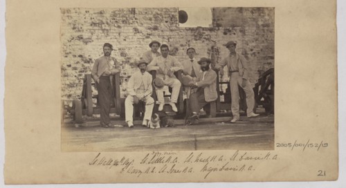 Group of men in civilian clothes pose against a wall