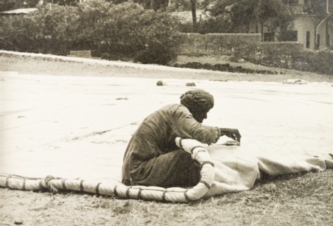 Sail maker repairing a dhow