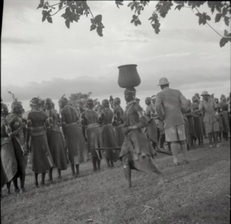 Woman going to inyangi, in front of ch. J. and dancers