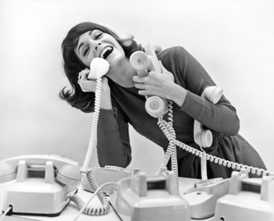 A woman tries to answer four telephones