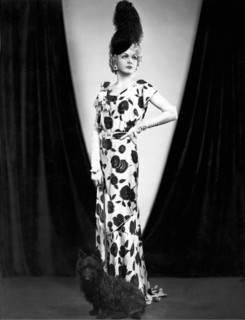 An elegant woman poses with her dog.