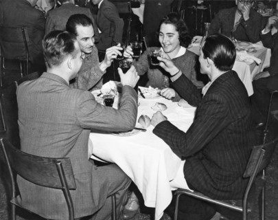 New York, New York:  c. 1939.
Four friends share a toast at a dinner in a restaurant.