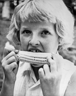 Coon Rapids, Iowa:  July 27, 1962.
A nine year old girl with a missing front tooth eats sweet corn