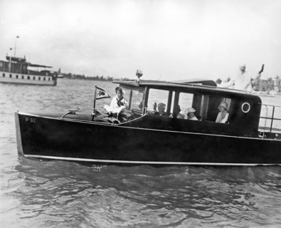 Gar Wood, international speed boat king, at the helm of his newe