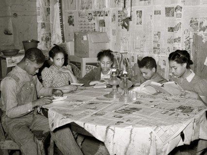 Five children of Pomp Hall, Black tenant farmer, studying their lessons by lamplight. Creek County, Oklahoma. 1938