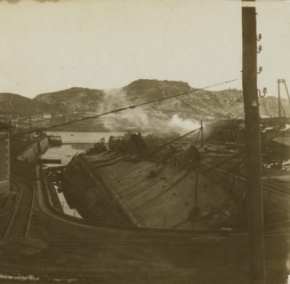 A warship on its side at a quay, Port Arthur 1905