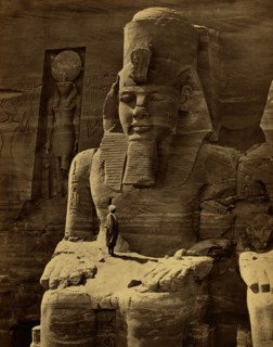 View of colossal figure, probably Ramses II, carved into rock that is the Great Temple at Abu Sunbul, Egypt. 1865