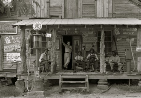 African American and a white store owner on the Porch of a country store 1939