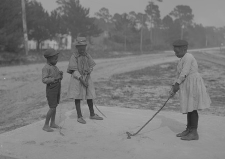 African American Children pretend to play golf on country road 1905