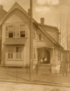 African American family posed on porch of house 1899