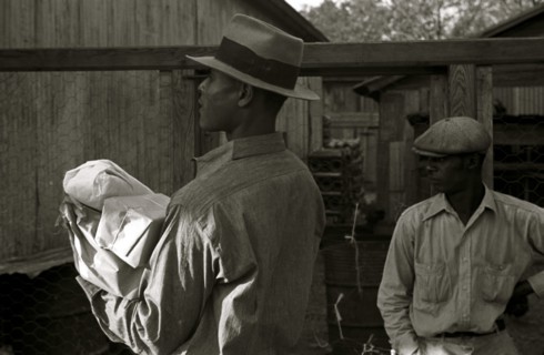 African American in hat carries packages 1935