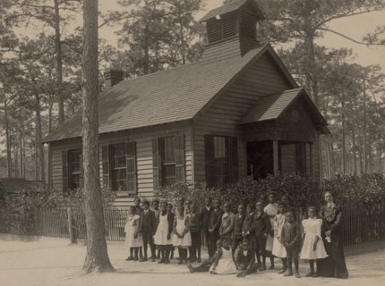African American school children posed with their teacher outside a school, possibly in South Carolina 1905