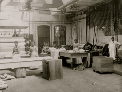 African American women and men posed by machinery, Lexington Laundry 1899