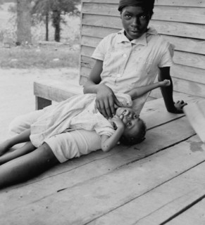 African American young girl with a small child on a porch 1939