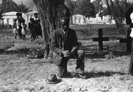 Black crossing himself and praying over grave of relative in cemetery, All Saints' Day, New Roads, Louisiana 1938