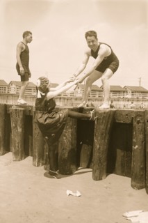 Boy Lifts Girl from the beach bulkhead