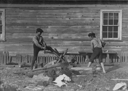 Two young boys from the Cotton Mill use a large crosscut saw 1908