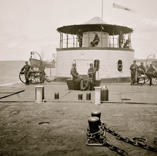 Charleston Harbor, S.C. Deck and officers of U.S.S. monitor Catskill; Lt. Comdr. Edward Barrett seated on the turret 1865