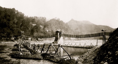 Chinese built suspension bridge, boats docked at pier in foreground, Szechwan Province, China