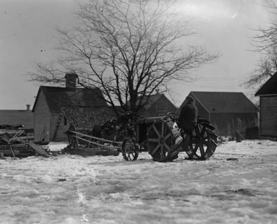 Farmer Drives Ford Tractor in yard 1924