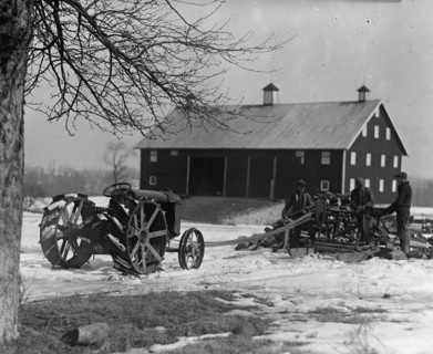 Farmer Drives Ford Tractor in yard 1924