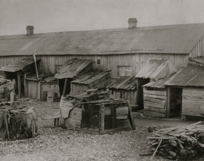 Father taking it easy at home while his two girls work in the cotton mill. 1911
