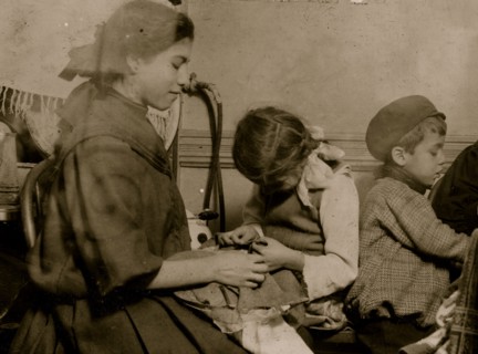 Italian Family works on garments in their tenement apartment 1911