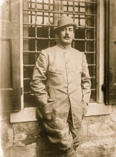Giacomo Puccini in jacket, smoking cigarette nown