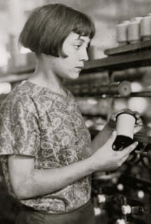 Girl holds a spool of silk thread 1924