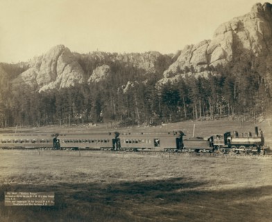 Full view of as train coming through the mountains in the West 1891