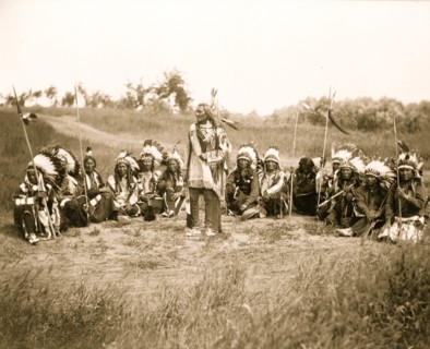 Chief Little Wound in council with other Indians, wearing feather headdresses 1899