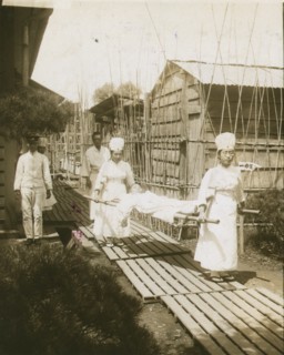 Japanese nurses carrying a patient on a stretcher 1905