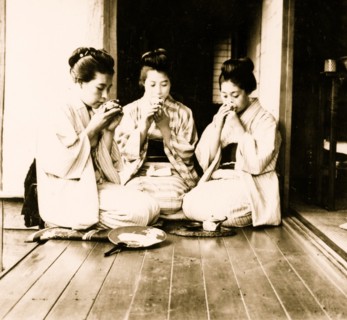 Japanese women seated on floor sipping tea. 1901