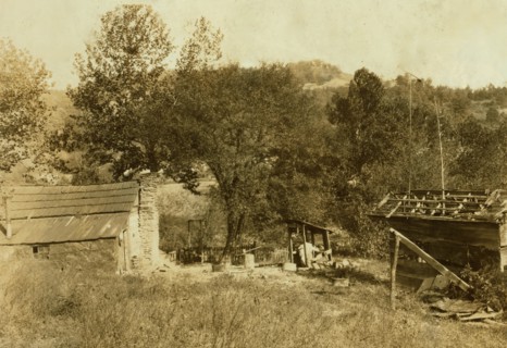 little log cabin, - relic of the old days, - now occupied by a small family (F.T. Castle) who are gradually giving up farming and depending upon mining and odd jobs. Oct. 12, 1921. (Dogs). Location: B...